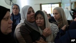 Mourners cry after taking the last look at the body of Mahmoud Abu Saan, 18, at a mosque during his funeral in the West Bank city of Tulkarem, Aug. 4, 2023. 