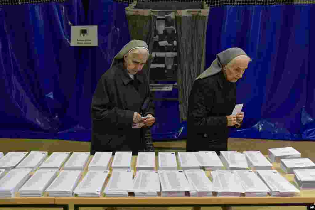 Nuns look at ballot papers at a polling station in Pamplona, northern Spain, June 9, 2024. 