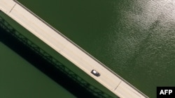 In this aerial photo, a car crosses the Enterprise Bridge at Lake Oroville in Oroville, California, on April 16, 2023.