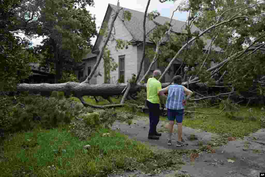 Jackie Jecmenek, a la derecha, habla con el trabajador municipal Bobby Head, frente a la casa de su vecino después del paso de Beryl en Bay City, Texas.&nbsp;