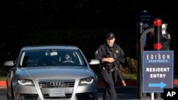 La policía del condado de Cobb registra autos cuando salen de los apartamentos Edison en Smyrna, Georgia, cuando buscaban a Deion Patterson, sospechoso de matar a una persona y herir a cuatro más el 3 de mayo de 2023.