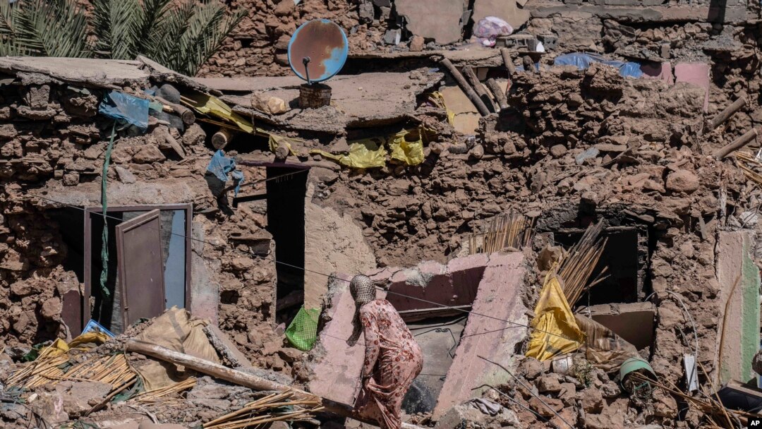 A woman tries to recover some of her possessions from her home which was damaged by the earthquake in the village of Tafeghaghte, near Marrakech, Morocco, Sept. 11, 2023. 