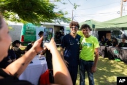 Dr. Pedro Juan Vázquez, better known by his stage name PJ Sin Suela, poses for a photo with a fan while on his rounds in Loiza, Puerto Rico, Saturday, May 25, 2024. (AP Photo/Alejandro Granadillo)