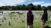 FILE - Widow Sitirokayah Salaeh (R) visits the cemetery in Tak Bai where her late husband Mahamad Lohbako is buried together with other anti-government demonstrators who died during the 2004 Tak Bai incident, in Narathiwat Province, Oct. 24, 2019. 