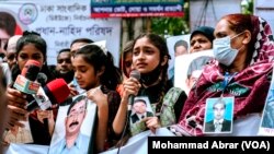 FILE - People with photos of alleged victims of enforced disappearances, in protest during the International Week of the Disappeared, Dhaka, Bangladesh, May 27, 2023.