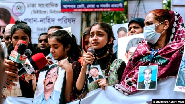 FILE - People with photos of alleged victims of enforced disappearances, in protest during the International Week of the Disappeared, Dhaka, Bangladesh, May 27, 2023.