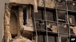 A person looks out of a damaged building in Kyiv, Ukraine, on Aug. 2, 2023, following Russian drone attacks. Britain on Aug. 8, 2023, imposed sanctions on an Iranian drone maker and other foreign businesses, accusing them of supplying Russia with weapons.