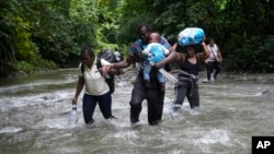 FILE - Haitian migrants wade through a river as they cross the Darien Gap, from Colombia into Panama, hoping to reach the U.S., Oct. 15, 2022. (AP Photo/Fernando Vergara, File)