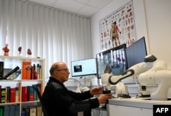 Doctor Guenter Steinebach works at a doctor's workplace for remote diagnosis in the laboratory of the Research Center Geriatronics of the Technical University Munich, in Garmisch-Partenkirchen, southern Germany, on March 6, 2023.