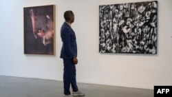 Brent Leggs looks at Anicka Yi's 'The Mother Tongue' (L) and Adam Pendleton's 'Untitled (Days for Nina)' (R) displayed as part of the Nina Simone Childhood Home Auction Exhibition at the Pace Gallery in New York on May 19, 2023.