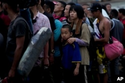 FILE - Chinese migrants line up to take a boat to Lajas Blancas after walking across the Darien Gap in Bajo Chiquito, Panama, May 7, 2023.