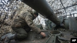 A soldier of the 12th Special Forces Azov Brigade of Ukraine's National Guard prepares to fire a 155mm self-propelled gun M109 Paladin towards Russian positions at the front line, near Kreminna, in Ukraine's Luhansk region, Jan. 28, 2024.