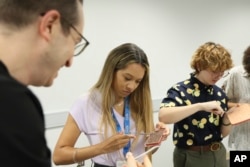 Sydney Sharpe and Dandelion Risch practice common dermatologic procedures during a hands-on bioskills workshop offered in collaboration with Nth Dimensions at the George Washington University Student Center in Washington on July 14, 2023. (Joshua Lee Reed/AAD via AP)