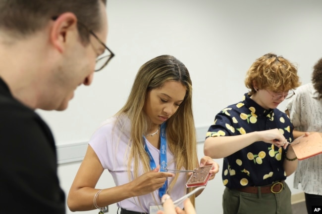 Sydney Sharpe and Dandelion Risch practice common dermatologic procedures during a hands-on bioskills workshop offered in collaboration with Nth Dimensions at the George Washington University Student Center in Washington on July 14, 2023. (Joshua Lee Reed/AAD via AP)