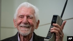 Marty Cooper, inventor del primer teléfono móvil comercial, posa para la prensa con un Motorola DynaTAC 8000x, en el Mobile World Congress 2023 en Barcelona, España, el lunes 27 de febrero de 2023. (Foto AP/Joan Mateu Parra)