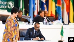 FILE - Rwanda's President Paul Kagame, then chairman of the African Union, signs the African Continental Free Trade Area agreement during the 10th Extraordinary Session of the African Union in Kigali, Rwanda, March 21, 2018. 