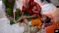 FILE - A paramedic gives an injection to a child suffering from dengue at Mugda Medical College and Hospital in Dhaka, Bangladesh, Aug. 10, 2023. 