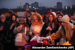 Orang-orang meletakkan bunga dan menyalakan lilin di samping Balai Kota Crocus, di tepi barat Moskow, Rusia, 23 Maret 2024. (AP/Alexander Zemlianichenko)