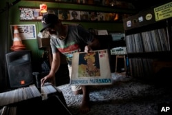 DJ Mustafa Baba-Aissa (Aljazair), menunjukkan salinan album The Brazil Bombshell Ace of Hearts 1965 milik Carmen Miranda, di toko kaset Vinil do Mustafa miliknya, di Rio de Janeiro, Brazil, Jumat, 19 April 2024. (AP/Bruna Prado)