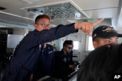 Philippine coast guard Petty Officer 2nd Class Mark Gayol gives instructions on board the BRP Malabrigo as they try to drive out suspected Chinese militias at the South China Sea, April 21, 2023.