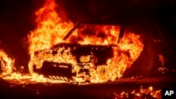 Flames consume a vehicle as the Park Fire burns in Tehama County, Calif., on July 26, 2024. 