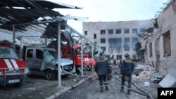 Ukrainian rescuers walk past damaged emergency service trucks next to a damaged fire station after a strike in the eastern Ukrainian city of Dnipro, amid the Russian invasion of Ukraine, in this handout photo published May 22, 2023. (AFP/State Emergency Service of Ukraine )
