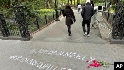 Sejumlah warga berjalan melewati grafiti yang dibuat untuk menarik perhatian terkait kasus kematian Jordan Neely di Washington Square Park, pada 5 Mei 2023. (Foto: AP/Brooke Lansdale)