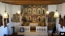 The preserved wood altar in the Holy Rosary Mission Church in the village of Truchas, New Mexico, April 16, 2023. Volunteers worked to save the 1760s adobe church and brought in Felix Lopez — an artist trained in New Mexico's centuries-old tradition of religious sculpture and painting — to help clean and preserve the altarpiece.