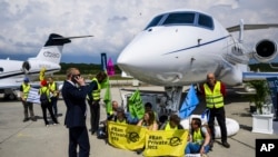 FILE - Environmental activists chained themselves to a plane at the Geneve Aeroport in Geneva, Switzerland, May 23, 2023. (Laurent Gillieron/Keystone via AP, File)