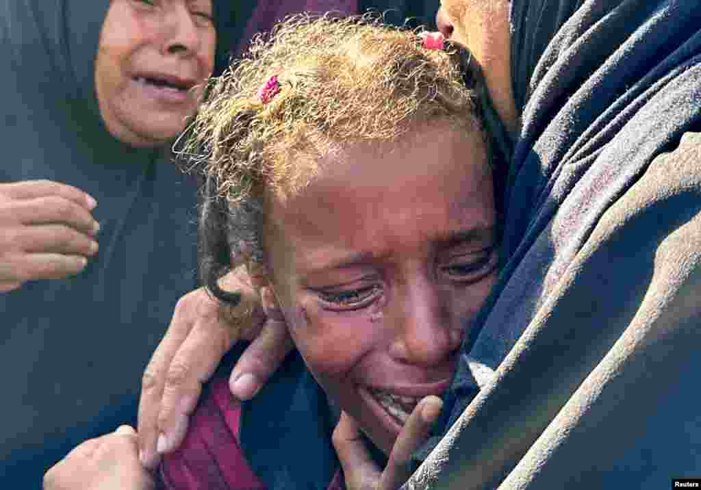 A mourner reacts during the funeral of Palestinians killed in Israeli strikes, amid the Israel-Hamas conflict, in Deir Al-Balah, in central Gaza Strip.