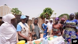 Philomena Irene, UNICEF nutrition specialist, speaks to women about food that will boost nutrient intake, in Kaltungo Poshereng, Nigeria, June 2, 2024. UNICEF said June 6 that one in four children under age 5 worldwide is experiencing severe food poverty.