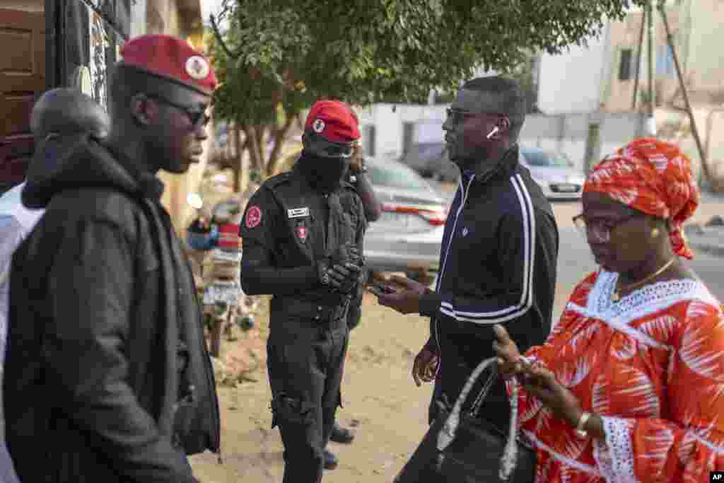 Security forces inspect people's identification cards outside a polling station during the presidential elections, in Dakar, Senegal, March 24, 2024. 