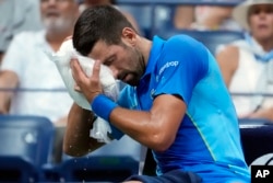 FILE - Novak Djokovic cools off during a break at the U.S. Open tennis championships on Sept. 3, 2023, in New York. Speaking about mental health, Djokovic said, "For quite a few years, actually, mental training was not really talked about much, generally, in the tennis world."