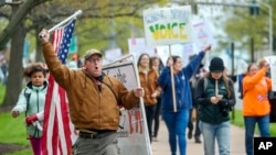 FILE - Opponents of a bill to repeal Connecticut's religious exemption for required school vaccinations march down Capitol Avenue before the State Senate voted on legislation on April 27, 2021, in Hartford, Conn. 