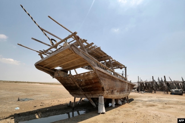 A traditional wooden ship, called a lenj, is laid ashore for restoration, in Iran's touristic Qeshm island in the Gulf, on April 29, 2023.