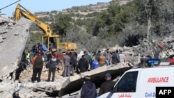 Warga dan tim penyelamat memeriksa kawasan yang hancur akibat pemboman Israel semalaman di desa Kafra di Lebanon selatan, 29 Februari 2024. (MAHMOUD ZAYYAT / AFP)