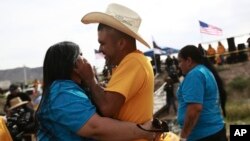 People living in the U.S. embrace with people living in Mexico during the 10th annual 'Hugs not Walls' event, on a stretch of the Rio Grande, in Ciudad Juarez, Mexico, May 6, 2023.