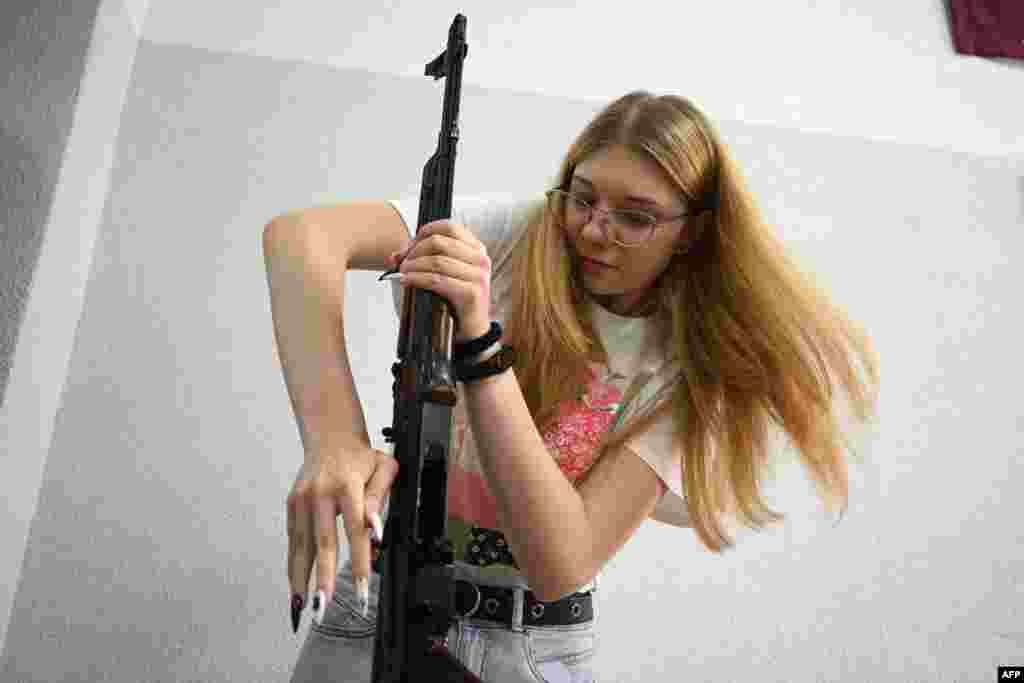 A girl takes apart a Kalashnikov rifle during a training lesson focused on the &quot;Defence of Ukraine&quot; at the military-patriotic center for schoolchildren in Lviv, amid the Russian invasion of Ukraine.
