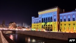 This picture shows the Sarajevo city hall lit up with the colors of the Ukrainian flag, late on Feb. 24, 2022. 