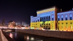 This picture shows the Sarajevo city hall lit up with the colors of the Ukrainian flag, late on Feb. 24, 2022. 