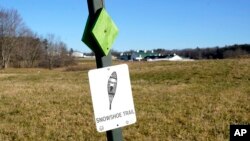 A trail sign for a snowshoeing route is seen on a snowless field at Pineland Farms, Dec. 21, 2023, in New Gloucester, Maine.