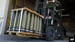 FILE - Airmen with the 436th Aerial Port Squadron use a forklift to move 155 mm shells ultimately bound for Ukraine, at Dover Air Force Base, Delaware, April 29, 2022.