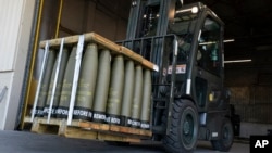 FILE - An airman with the 436th Aerial Port Squadron uses a forklift to move 155 mm shells ultimately bound for Ukraine, at Dover Air Force Base, Delaware, April 29, 2022.