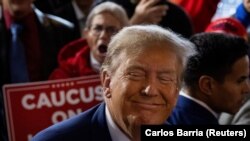 Mantan Presiden AS dan calon presiden dari Partai Republik Donald Trump bersama para pendukungnya pada acara "berkomitmen pada kaukus" di bar Whiskey di Ankeny, Iowa, AS 2 Desember 2023. (Foto: REUTERS/Carlos Barria)