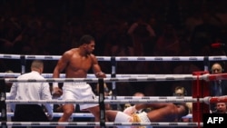 British boxer Anthony Joshua (L) competes with Cameroonian-French boxer Francis Ngannou during their heavyweight boxing match in Riyadh's Kingdom Arena indoor stadium, on March 9, 2024. 