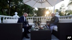 Russian President Vladimir Putin, left, speaks with Indian Prime Minister Narendra Modi during an informal meeting at Novo-Ogaryovo residence, outside Moscow, July 8, 2024.