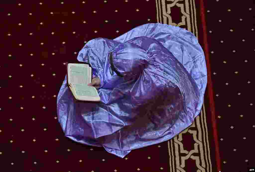 A Muslim woman reads a copy of the Quran on the fourth day of the holy month of Ramadan at the Istiqlal mosque in Jakarta, Indonesia.