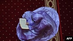 A Muslim woman reads a copy of the Quran on the fourth day of the holy month of Ramadan at the Istiqlal mosque in Jakarta, Indonesia.