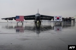 지난해 10월 한국 청주 공군기지에 착륙한 미 공군 B-52H 전략폭격기가 앞에 미한 양국 국기가 세워져있다.