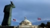 FILE - A bronze statue of San Juan Bautista stands in front the Capitol building flanked by US and Puerto Rican flags, in San Juan, Puerto Rico. 